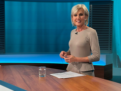 Volksanwältin Gaby Schwarz steht in einem beigen Kleid im ORF Bürgeranwalt Studio.