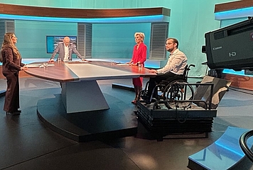 4 Personen stehen im ORF Studio, darunter Volksanwältin Gaby Schwarz und neben ihr der Beschwerdeführer im Rollstuhl.