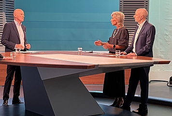 Volksanwältin steht im ORF Studio zwischen dem Moderator und dem Beschwerdeführer