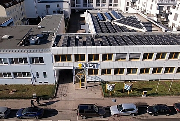 Das Bild zeigt die Betriebseinfahrt mit Autos, die in der ehemaligen Zustellzone parken.