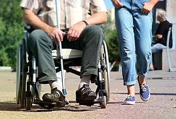 Person mit Rollstuhl und Langstock, Person zu Fuß