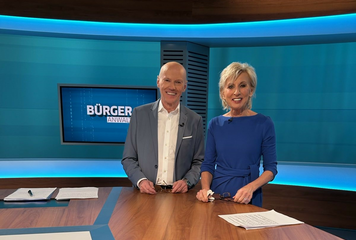 ORF Moderator Peter Resetarits und Volksanwältin Gaby Schwarz stehen im Bürgeranwalt Studio.