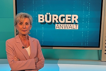 Volksanwältin Gaby Schwarz steht im ORF Studio vor einem Screen mit dem Titel "Bürgeranwalt".