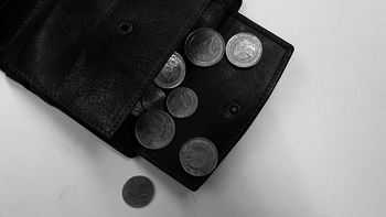 Ein Portemonnaie, vor dem Münzen liegen